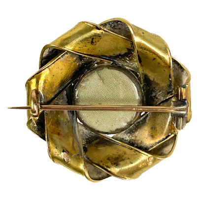 Lot 2 - A Victorian gold (tests 14ct) blue guilloche enamel and seed pearl set knot brooch.