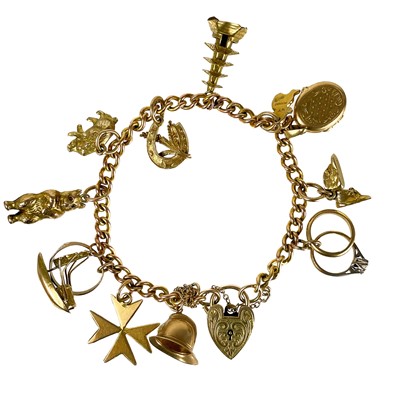 Lot 11 - A 9ct gold charm bracelet applied with many charms.