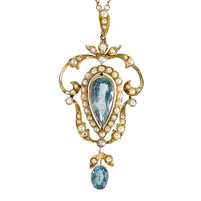 Lot 15 - An Art Nouveau gold openwork aquamarine and seed pearl set pendant.