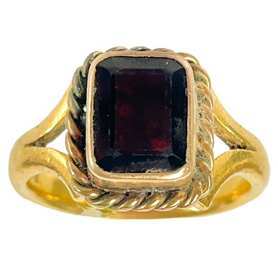 Lot 17 - A Victorian 22ct and lower grade gold garnet set single stone ring.