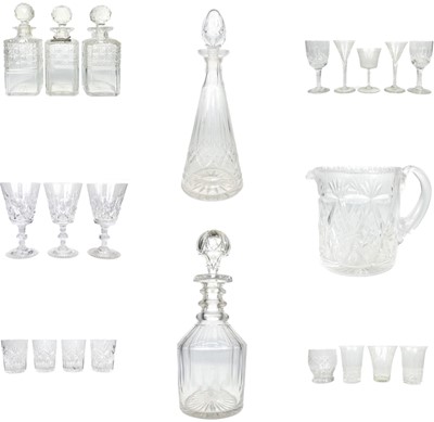 Lot 589 - A set of three cut glass decanters and faceted stoppers.