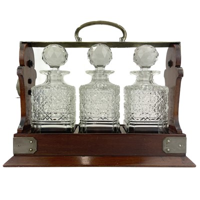 Lot 105 - A Betejeman's patent three bottle mahogany tantalus.