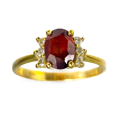 Lot 124 - A modern 18ct gold diamond and garnet set seven stone ring.