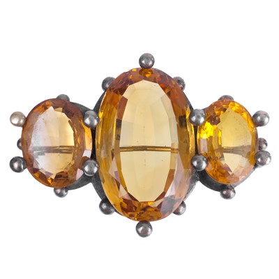 Lot 276 - A Scottish silver hardstone oval brooch and a silver citrine set three stone brooch.