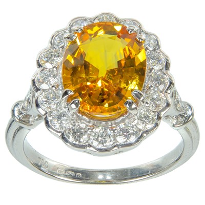 Lot 132 - An 18ct white gold,  3ct (approx) yellow sapphire and diamond cluster ring.