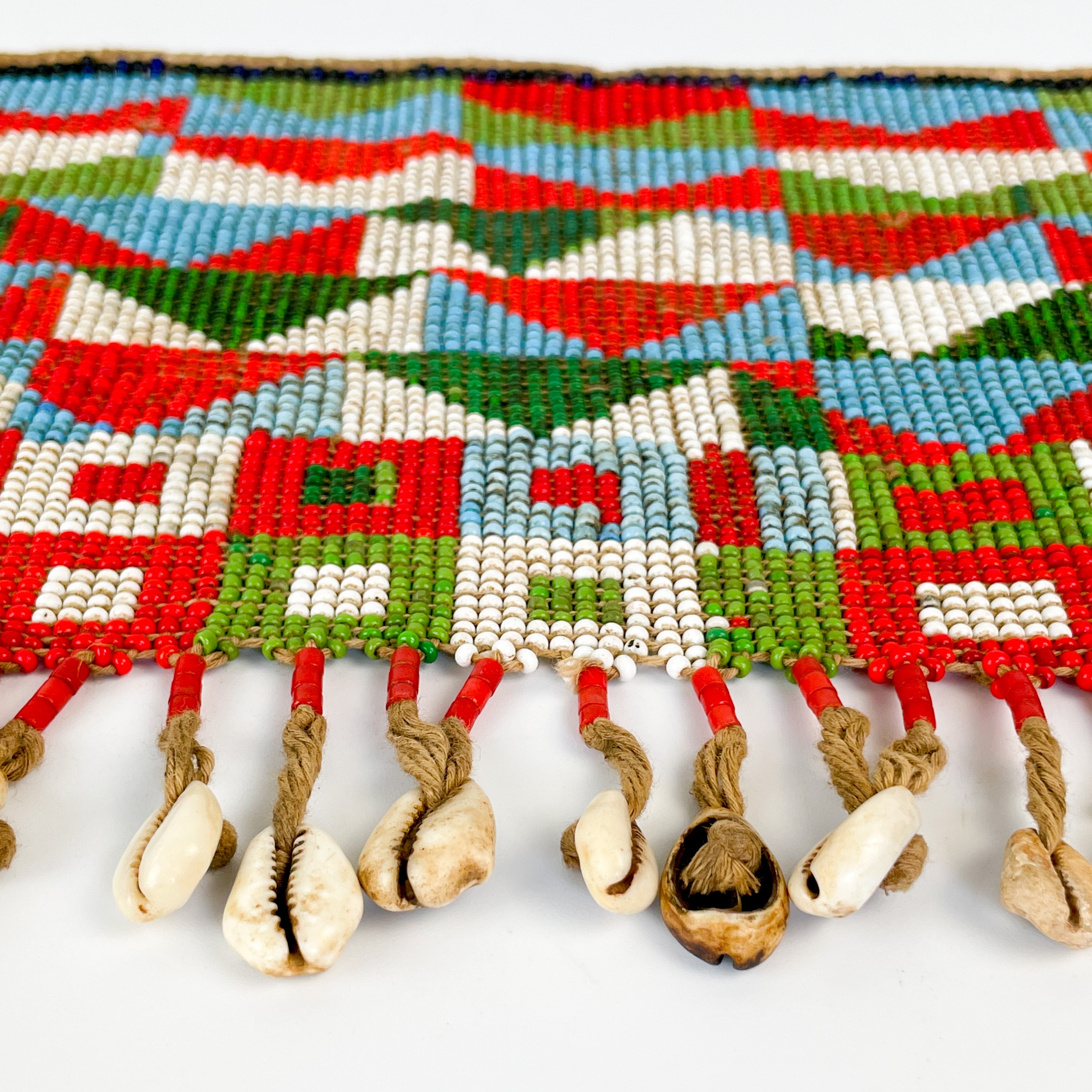 Shell Apron Lot 157 - An Angolan beadwork and cowrie shell apron,