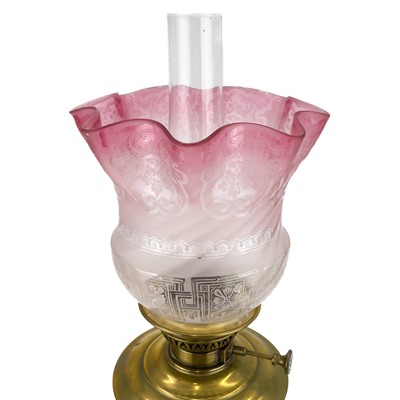 Lot 251 - A Victorian brass oil lamp with an etched cranberry glass shade.