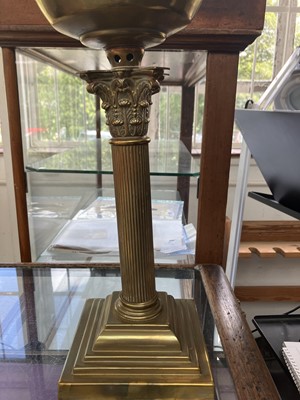 Lot 251 - A Victorian brass oil lamp with an etched cranberry glass shade.