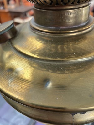 Lot 251 - A Victorian brass oil lamp with an etched cranberry glass shade.
