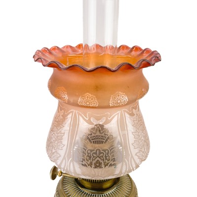 Lot 14 - A Victorian brass oil lamp with a brass oil reservoir and an etched orange glass shade.