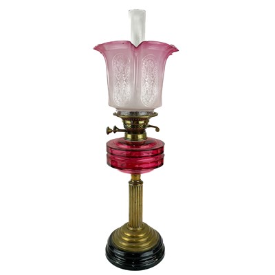 Lot 119 - A Victorian brass oil lamp with a cranberry reservoir and cranberry glass shade.