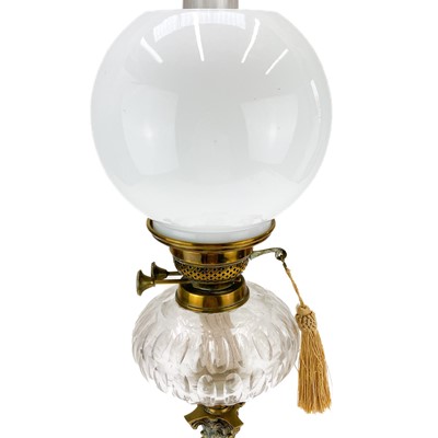 Lot 21 - A Victorian brass oil lamp with a clear glass oil reservoir and white glass shade.