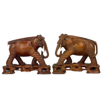 Lot 402 - A pair of Chinese carved wood elephants on stands.