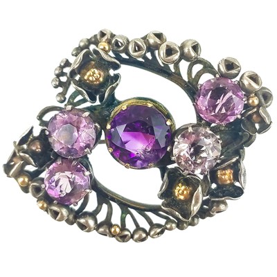 Lot 321 - Frederick James Partridge (1877-1942) An Arts & Crafts silver and amethyst set floral brooch.