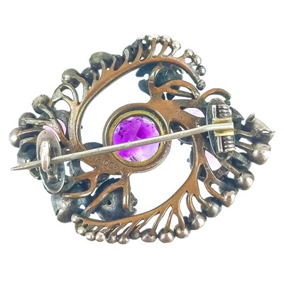 Lot 321 - Frederick James Partridge (1877-1942) An Arts & Crafts silver and amethyst set floral brooch.