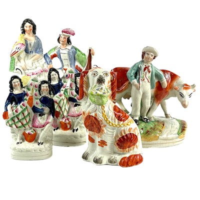 Lot 98 - A Staffordshire figure of a spaniel with a basket of flowers.