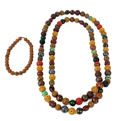 Lot 451 - A South East Asian carved bead and glass long necklace.