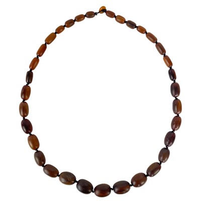 Lot 1312 - A graduated horn oval bead necklace, Qing dynasty