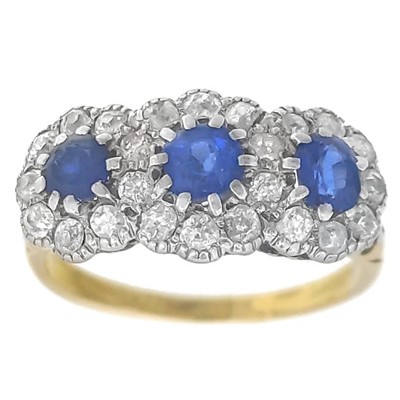 Lot 432 - An 18ct three-stone sapphire and diamond set ring.