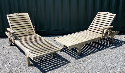 Lot 362 - A pair of slatted teak garden steamer chairs.