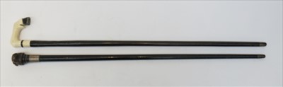 Lot 409 - A Victorian ebonised walking cane, the carved...