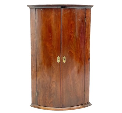 Lot 646 - A George III mahogany bow front corner cupboard.