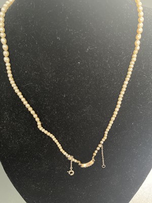 Lot 444 - A Georgian graduated natural saltwater pearl necklace with rose gold seed pearl and hair panel clasp.