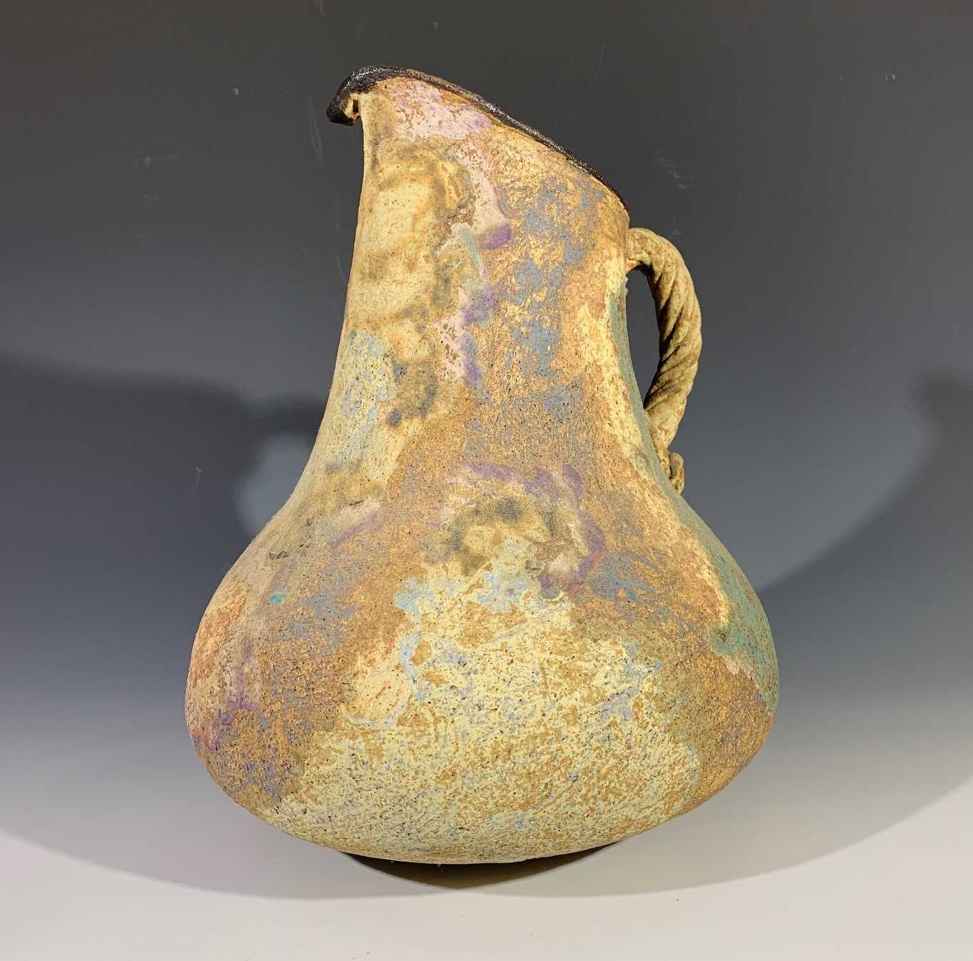 Lot 1489 - A studio pottery ewer with rope twist handle.
