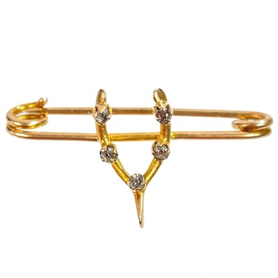 Lot 470 - A 15ct gold diamond set wishbone brooch.