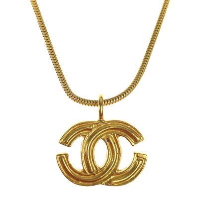 Lot 591 - A Chanel gold-tone CC pendant.