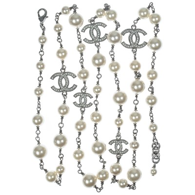 Lot 554 - A Chanel white metal cultured pearl and white gem set CC long necklace.