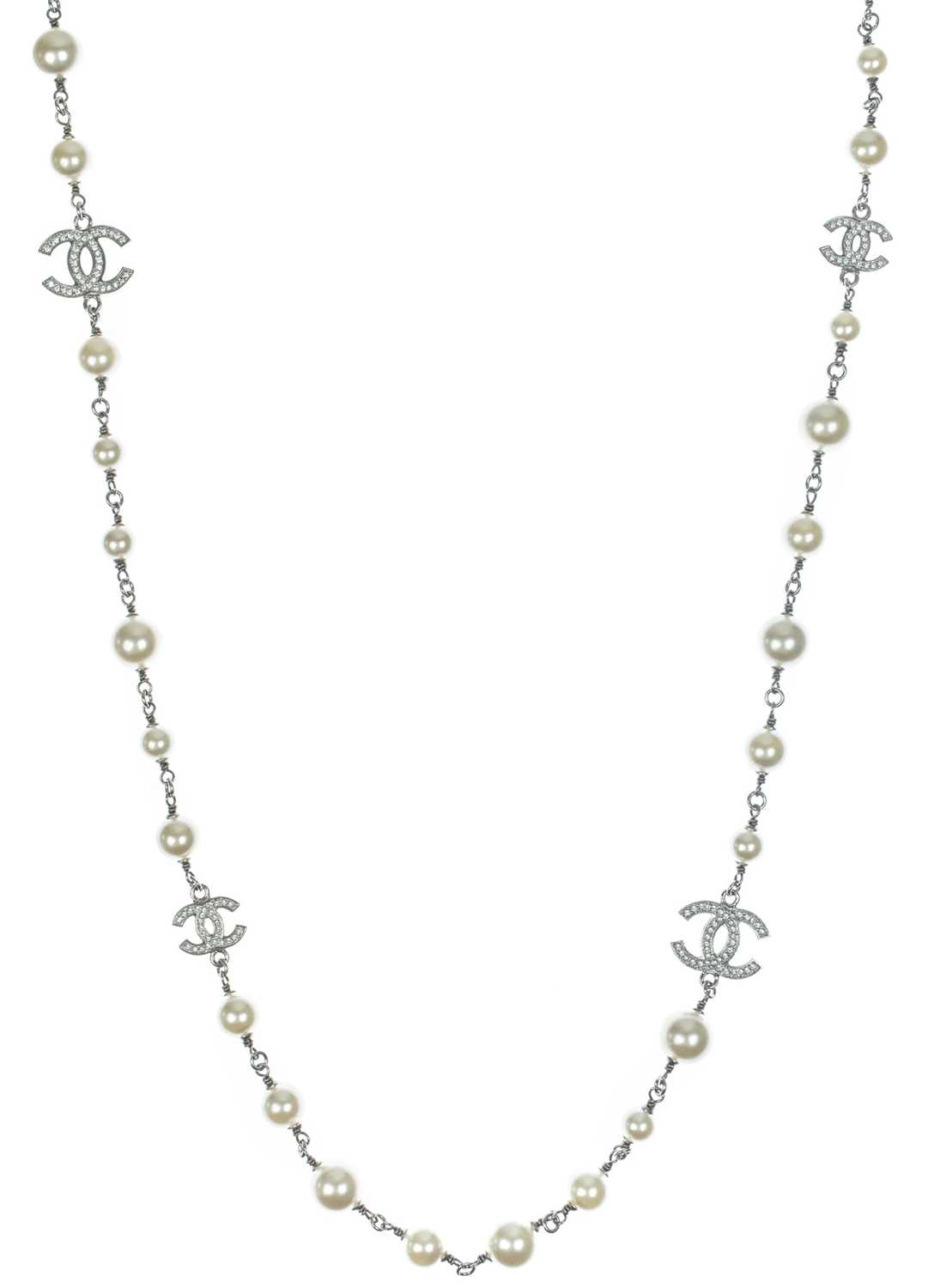 Lot 554 - A Chanel white metal cultured pearl and white gem set CC long necklace.