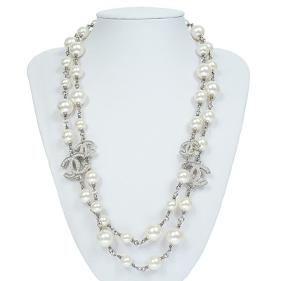 Lot 554 - A Chanel white metal cultured pearl and white gem set CC long necklace.