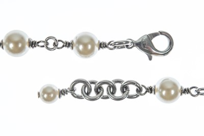 Lot 554 - A Chanel white metal cultured pearl and white gem set CC long necklace.