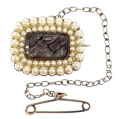 Lot 34 - A George IV gold mourning brooch with split seed pearls and a glazed hair panel.
