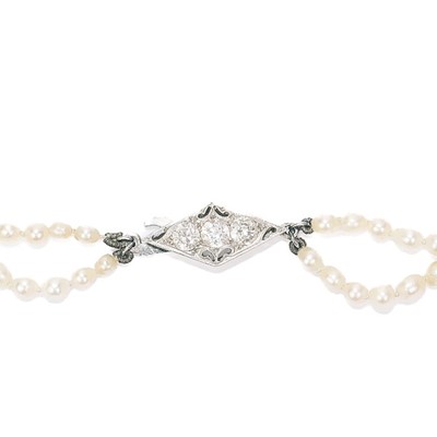 Lot 38 - A double-strand graduated cultured pearl necklace with three-stone diamond clasp.