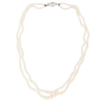 Lot 38 - A double-strand graduated cultured pearl necklace with three-stone diamond clasp.