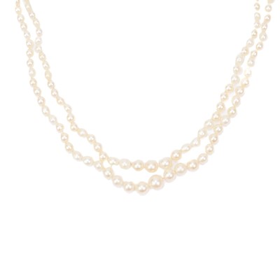 Lot 38 - A double-strand graduated cultured pearl necklace with three-stone diamond clasp.