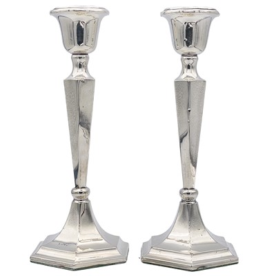 Lot 99 - A pair of George V silver candlesticks of hexagonal section.