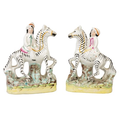 Lot 73 - A pair of Victorian Staffordshire figures of children riding zebras.