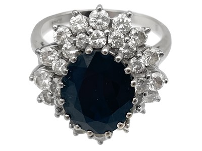 Lot 38 - An 18ct white gold diamond and sapphire cluster ring with a pair of matching earrings.