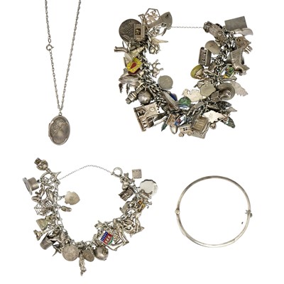 Lot 426 - Two silver charm bracelets, a silver locket and a bangle.