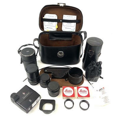 Lot 25 - A leather camera case containing Leica camera lenses and camera attachments.