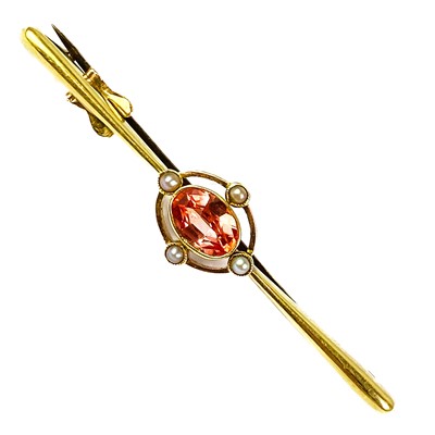 Lot 263 - An Edwardian peach sapphire, possibly Padparadscha, and seed pearl set bar brooch.