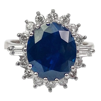 Lot 163 - An 18ct oval blue sapphire and diamond cluster ring.