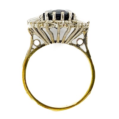 Lot 132 - An 18ct oval blue sapphire and diamond cluster ring.