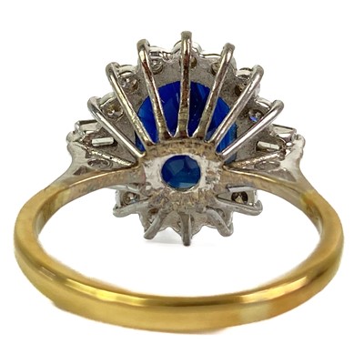 Lot 132 - An 18ct oval blue sapphire and diamond cluster ring.