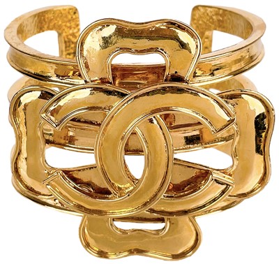 Lot 572 - A Chanel 24ct gold-plated CC and four-leaf clover applied bangle, circa 1994.