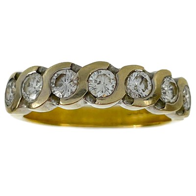 Lot 106 - A modern 18ct yellow and white gold diamond set seven-stone half hoop ring.