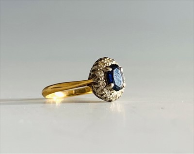 Lot 2450 - A gold sapphire and diamond oval cluster ring.